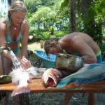 Aloe Driscoll and Leo Ramsey filleting fish.